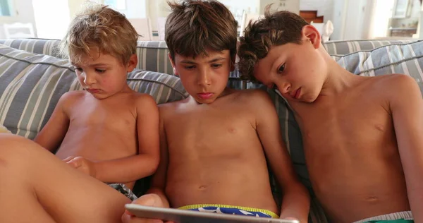 孩子们在家里在线观看平板电脑上的内容 孩子们凝视着屏幕 — 图库照片