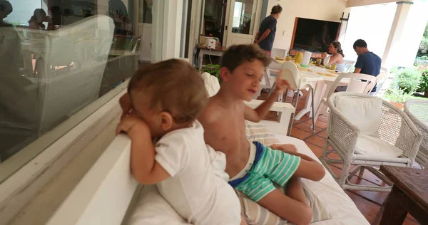 小男孩和他的哥哥一起爬到沙发上 — 图库照片