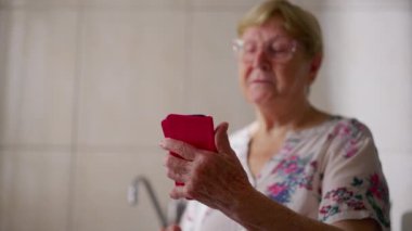 Teknoloji düşkünü son sınıf öğrencisi bir kadın telefon kullanıyor. 80 'li yaşlarda kadın cep telefonu cihazı taşıyor.