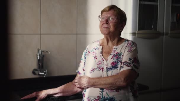 老太婆闷闷不乐地凝视着厨房的窗户 一位80多岁的高加索老年人陷入沉思 — 图库视频影像