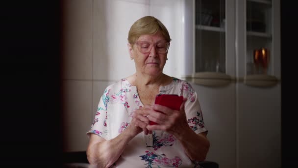 精通技术的老年妇女在家使用手机 老年妇女参与现代技术和在线浏览 — 图库视频影像