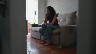 Düşünceli genç bir kadın kendini evde yalnız hissediyor. Evdeki kanepede oturuyor. 30 'lu yaşlardaki düşünceli kadın kendini yalnız hissediyor.