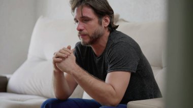 Geçmiş için pişmanlık duyan endişeli bir genç adam. 30 'lu yaşlarda bir erkek evde hüzün ve duygusal acıdan muzdarip.