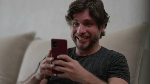 Happy Man Reageert Positief Nieuwsberichten Mobiele Telefoon Terwijl Hij Thuis — Stockfoto