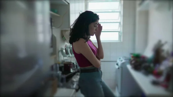 一人の思慮深い若い女性が 集中的な表情でキッチンに立っています 30代の女性はアパート内の決定を検討しています 家庭生活 — ストック写真