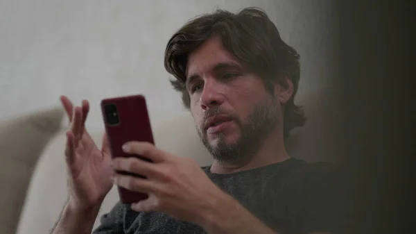 Ein Junger Mann Blättert Mit Ernstem Gesichtsausdruck Mit Dem Handy — Stockfoto