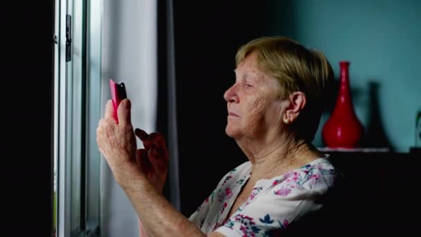 Oudere Vrouw Met Behulp Van Telefoon Door Home Window Depicting — Stockvideo