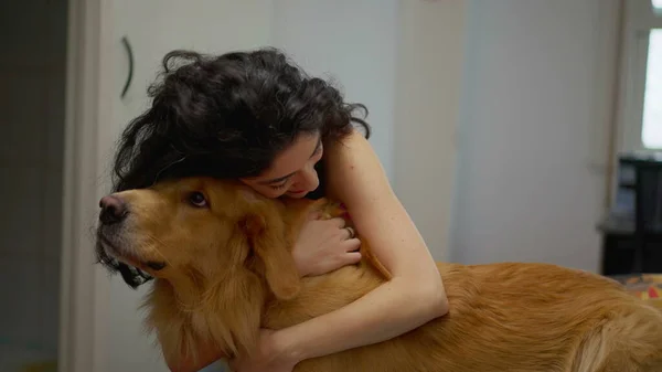 女人和心爱的金毛猎犬在家里共度温馨时刻 爱犬的主人拥抱着她的犬伴 — 图库照片