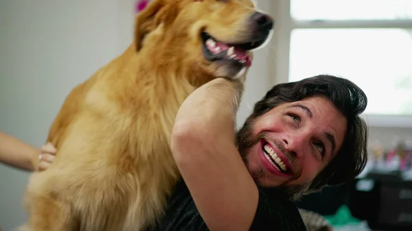 Happy Male dog owner interacting with playful Golden Retriever Pet indoors. Real life authentic Dog lover relationship