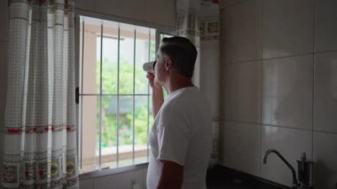 Mutfak Penceresinde Kahvesini yudumlayan Orta Yaşlı Adam 'ın Sabah Düşüncesi, Yerel Günlük Ayin