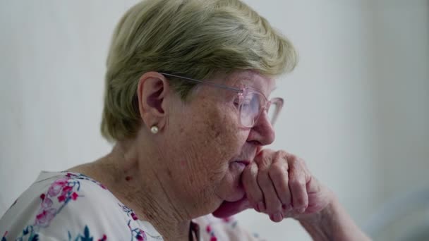 Evde Derin Düşüncelere Dalmış Yaşlı Kadın Yaşlılığın Otantik Tasviri — Stok video