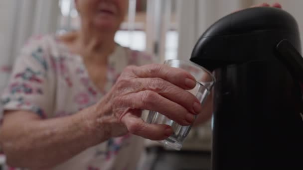 コーヒーをグラスカップに注ぐ魔法瓶トップを押すシニア女性 南アメリカ白人高齢者カフェを提供する人 — ストック動画
