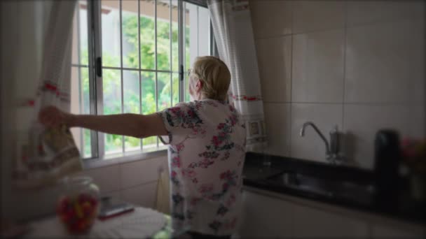 Starsza Kobieta Rozsuwa Zasłony Kuchni Rano Rytuał Starszej Kobiety Rozpoczynający — Wideo stockowe