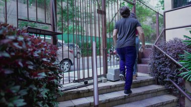 Çift apartmandan ayrılıyor. Kadın ve erkek kapıyı açıyor. Kaldırımdan çıkıyorlar.