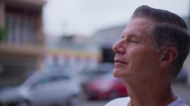 Minnettar kıdemli adam UMUT ve FAITH ile gökyüzüne gözlerini açıyor. Düşünceli, meditasyoncu yaşlı bir insan...