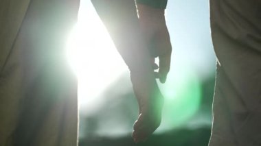 İki yaşlı insanın güneş ışığıyla el ele tutuşması. Evli bir çiftin destek ve yardımları arasında güzel bir romantik an.