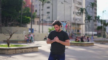 Düşünceli genç bir adam endişeli bir ifadeyle şehirde dikiliyor. Düşünceli erkek, ikilemde.