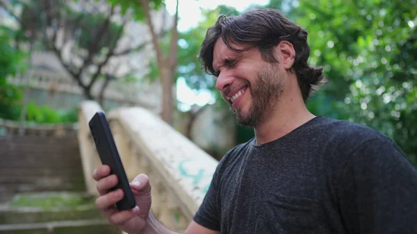 Счастливый Красавчик Лет Получает Положительное Сообщение Мобильном Телефоне Стоя Городском — стоковое фото