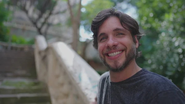 stock image Handsome Young Man Smiling at City Park standing outside in beautiful sunny day. 30s male person portrait face close up looking at camera