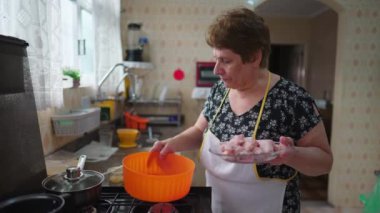 Hakiki ev hayatı sahnesinde kıdemli bir kadın yemek pişiriyor. Yaşlı adam kaseye tavuk koyup yemek hazırlıyor.