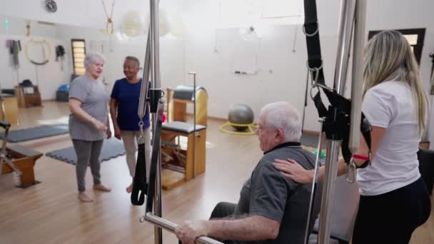 Pilates Coach Βοηθώντας Senior Άνθρωπος Ασκήσει Στο Pilates Studio Ομαδική — Αρχείο Βίντεο
