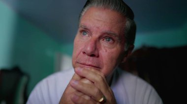 Düşünceli orta yaşlı bir adam evdeki sorunları düşünüp taşınıyor. Derin düşüncelere dalmış bir yüz ifadesi takınıyor.