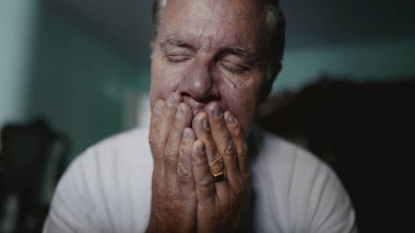 Beyaz, orta yaşlı bir adam, hayatın zorluklarıyla mücadele ediyor, baş ağrısı ve endişeden muzdarip, umutsuzluk içinde saklanan biri.