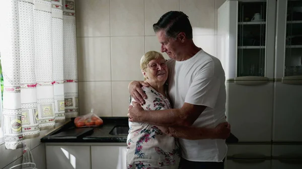 Hijo Adulto Abrazando Anciana Madre Pie Cocina Del Hogar Auténtico —  Fotos de Stock