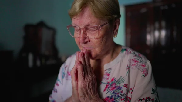 Hopeful Elderly Woman Praying to God, Sitting by Bedside in Bedroom, Authentic Domestic Lifestyle Reflecting Old Age and Faith