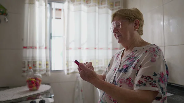 Пожилая Женщина Помощью Мобильного Телефона Кухне Домашний Образ Жизни Сцена — стоковое фото