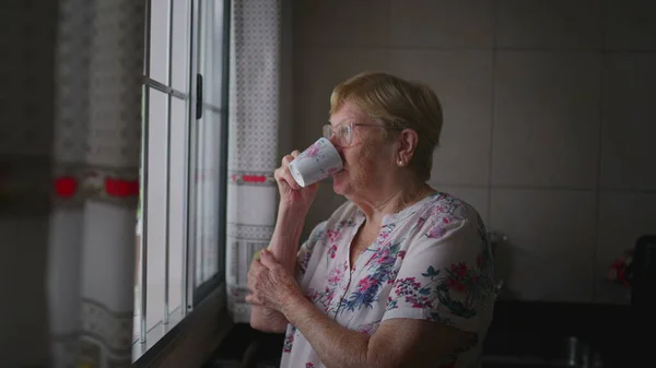 Kontemplativ Äldre Kvinna Smuttar Kaffe Vid Fönster Kök Vanliga Rituella — Stockfoto