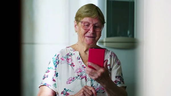 Старшая Женщина Просматривает Интернет Интернете Мобильного Телефона Отображая Счастье — стоковое фото