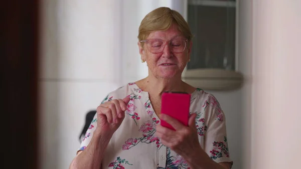 坎德老年妇女在家里的视频会议上向家人挥手致意 真正的老太太在和亲戚们说话 看着智能手机的显示屏 — 图库照片