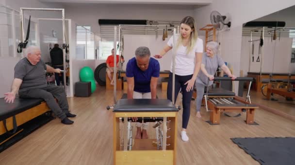 Grupo Idosos Fazendo Pilates Sessions Com Ajuda Instrutora Treinadora Homens — Vídeo de Stock