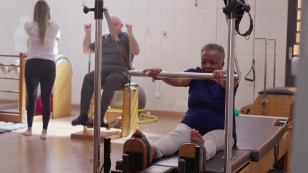 Старші Вправи Класі Pilates Group Чорношкіра Жінка Яка Використовує Машину — стокове відео