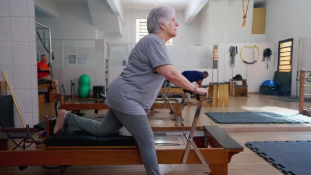 Oudere Vrouw Die Pilates Machine Gebruikt Het Lichaam Strekken Ouderen — Stockvideo