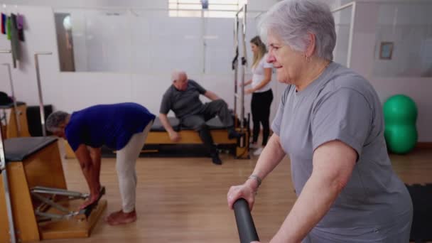 Fizyoterapi Grubunda Pilates Makinesiyle Egzersiz Yapan Yaşlı Bir Kadın Omurga — Stok video