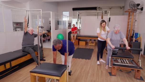 Pilates Grup Yaşlılar Egzersizi Eğitmen Koçunun Yardımıyla Makineleri Kullanmaları Için — Stok video