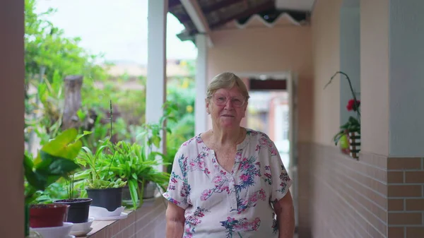 Casual Senior Mulher Fica Casa Quintal Olhando Para Câmera Rastreamento — Fotografia de Stock