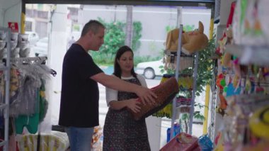 Yerel bir dükkan sahibi, Pet Shop 'un içinde Bed Dog ile müşteriye yardım ediyor.