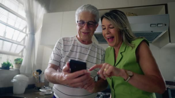 Coppia Anziana Guardando Dispositivo Cellulare Insieme Mentre Piedi Cucina Marito — Video Stock