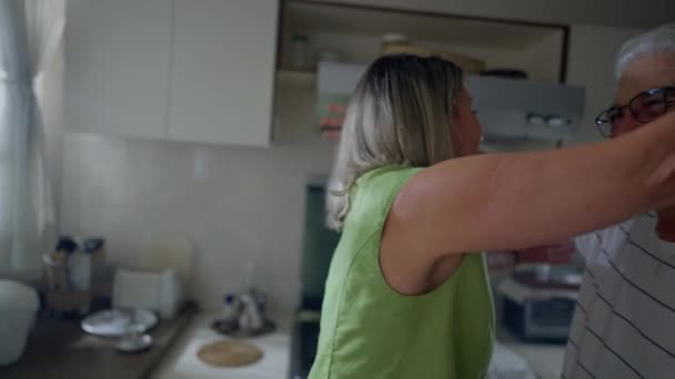 古い友人幸せな再会 キッチンでは中年の女性が年配の男性を抱きかかえています 本物の人々を受け入れる — ストック動画