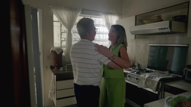 ロマンチックなシニアカップルは キッチンの設定で踊ります 引退した老人と自宅でダンスに従事女性 本物の国内ライフスタイルシーン — ストック動画