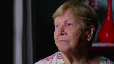 Hüzünlü bir yüz ifadesiyle yaşlı bir kadının yalnızlığını ve yalnızlığını tasvir eden son sınıf öğrencisi bir kadın.