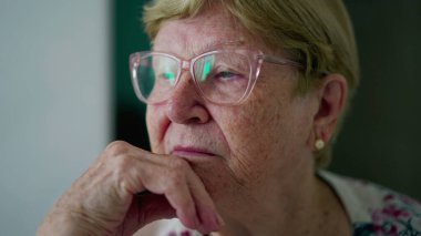 Düşünceli, son sınıf öğrencisi, yakın çekim yüzü. Derin düşüncelere dalmış 80 'li yaşlarda bir kadın. Geçmişteki tecrübelerini hatırlayan yaşlı kadının düşünceli ifadesi.