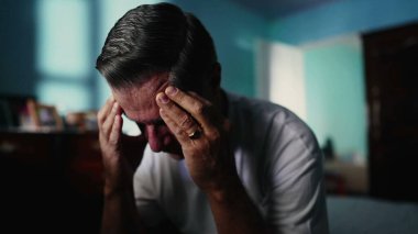 Bunalımda olan orta yaşlı bir adam yatak odasında tek başına acı çekerken zor zamanlarında umutlu bir ifadeyle kafasını pencereye kaldırıyor.