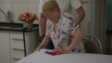 Yaşlı bir kadın, gerçek hayat tarzında, yaşlılığı resmeden gerçek bir yaşam tarzıyla evdeki sandalyesinden kalkıyor.