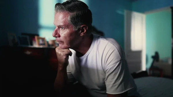 stock image Pensive senior man stuggling with mental illness in bedroom. Desperate Lonely person suffering from anxiety and despair