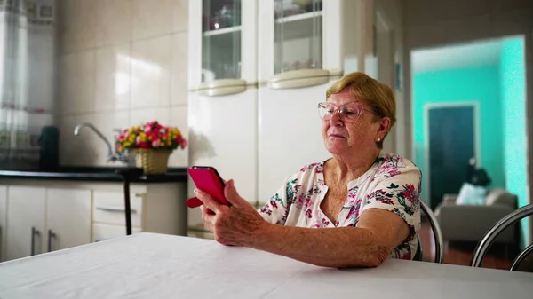 Пожилая Пожилая Женщина Использующая Смартфон Устройство Домашней Кухне Бытовой Образ — стоковое фото