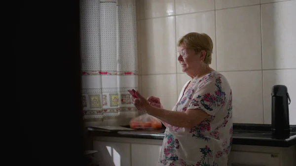 Candid Ältere Frau Mit Smartphone Gerät Hause Lehnt Waschbecken Der — Stockfoto